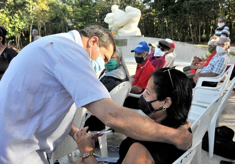 Ernesto Santiesteban Velázquez, primer secretario del Partido en Holguín, entrega el carné de militante del Partido a una nueva integrante de la organización política. pascuas acto h2