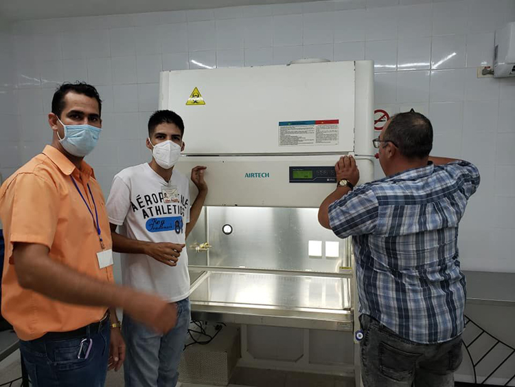 Luis Enrique (a la derecha) junto a su equipo de trabajo en instalación de Cabina de Seguridad Biológica Clase II, donde se inactiva el virus para poder comenzar procesamiento de muestra. Laboratorio839