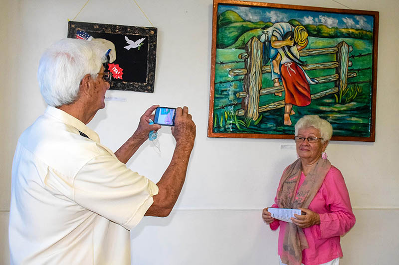 La artista Dalia Morín Mayoral posa junto a su obra "El beso". Expo Bloqueo 03